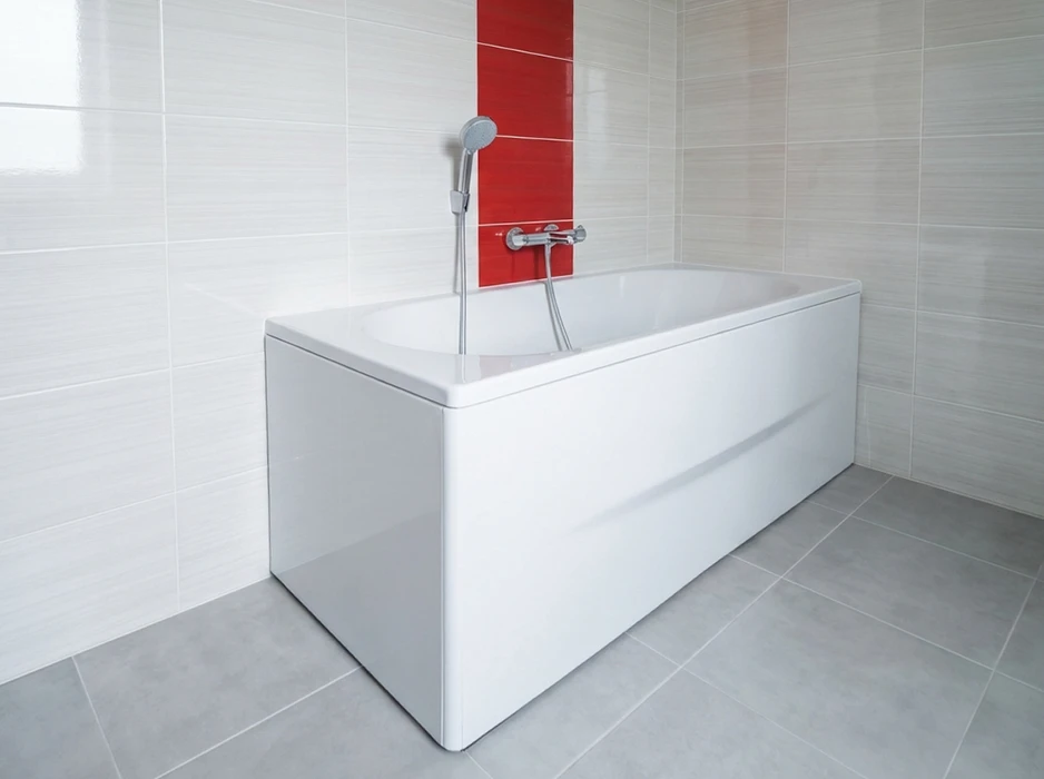 Salle de bain élégante combinant baignoire îlot sur pieds en fonte émaillée, extérieur terracotta, robinetterie colonne en laiton nickelé brossé, style victorien